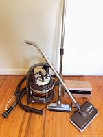 Overall view showing canister vacuum, hose, wands, power nozzle, floor head and accessory box