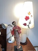 Ceramic lamp with pressed leaf shade, silver desk lamp, cloth figure overall view