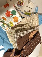 Group shot of all tea towels and aprons spread out
