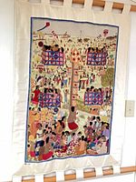 Full view of tapestry hanging with both wooden dowels and fabric tabs visible.