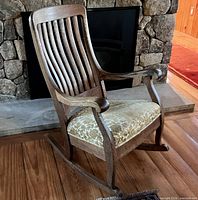 full view of rocking chair angled before stone fireplace