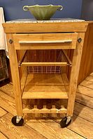 Front view of maple rolling kitchen island cart with bowl on top