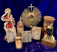 Group shot of all religious items including monstrance, statues, candle, copper plates