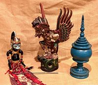 Group view of Garuda carving, Wayang puppet and Thai offering bowl