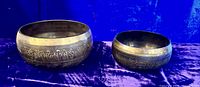 Both singing bowls side by side showing relative sizes and exterior etching