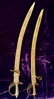 Two sabers in scabbards, showing overall appearance and engraving