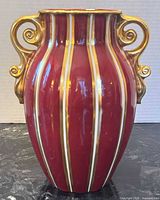 Front view of burgundy vase with gilt handles and stripes