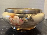 Side view showing floral decoration and gilt rim