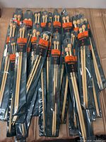 Pile of retail-packed bamboo needles showing Apple branding and knob ends