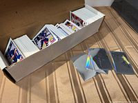 open cardboard box filled with stacks of hockey trading cards and several plastic card sleeves