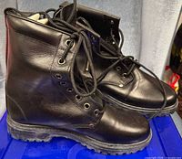 Side view of both boots showing leather uppers, laces, and soles