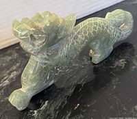 Profile view of carved jadeite dragon, showing overall form and scale detail