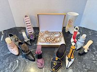 Group shot of all shoe figurines, vase and boxed necklace