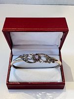 Bangle in red display box, showing filigree design and amethyst stone