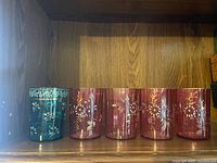 All five tumblers on shelf showing color and matching decoration