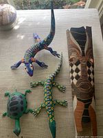 Group shot of four wooden animals and mask