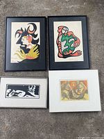 Four framed artworks laid out on ground