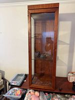 Full front view of teak glass display cabinet on table