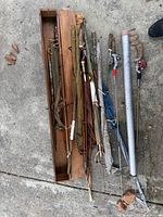 Overall lot showing rods, wooden box, aluminum tube