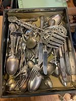 Box filled with assorted silver-plated flatware pieces