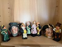 Full set of eight Royal Doulton pieces on shelf