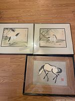Overview of three framed horse prints on floor