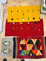 Overview of four woven pieces laid out on floor