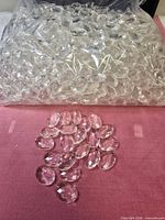 Sealed bag filled with clear oval acrylic beads, some beads spread out for view