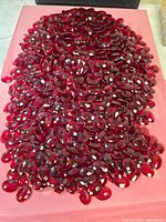 Large pile of red oval rhinestones on tray