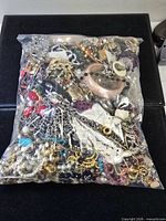 Full view of sealed bag densely filled with assorted jewelry pieces