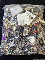 Full view of sealed plastic bag packed with mixed costume jewelry