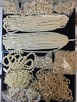overview of bundled strands and assorted bags of faux pearl beads