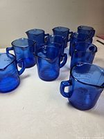 Group of 10 cobalt blue measuring cups on tabletop