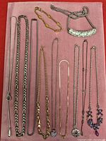 Overview of all necklaces and bracelet laid on pink board
