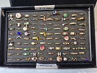 Full tray with about 100 gold-tone costume rings in foam display