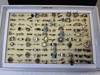 Entire tray with 100 silver-tone costume rings