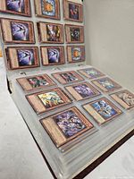 Binder open showing multiple nine-pocket pages of Yu-Gi-Oh! cards