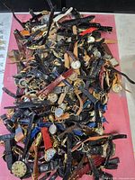 Top view of entire pile of wristwatches showing quantity and strap variety