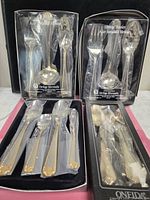 Four boxed sets showing two place-setting boxes and two serving-piece boxes