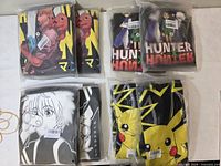 Six of the eight sealed graphic hooded T-shirts shown in packaging