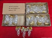 Three open cartons showing packed clear acrylic grape clusters and three loose examples