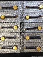 Ten identical goldtone watches laid out on bubble wrap