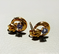 Front view of both 18K yellow gold earrings showing circular design and blue stones