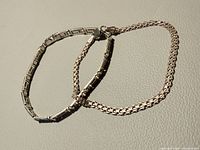 Both sterling silver bracelets laid flat showing overall style and lengths