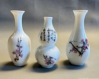 Front view of three small porcelain vases