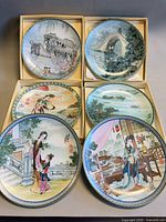 Six decorative porcelain plates displayed, each in open box