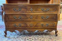 Full frontal view of walnut chest showing drawers, hardware and carved skirt
