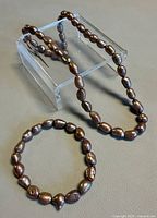 Necklace arranged on stand with bracelet shown