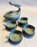 Full tea set displayed: teapot, four cups on saucers