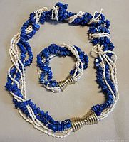 Necklace and bracelet laid out showing overall design, materials and clasp